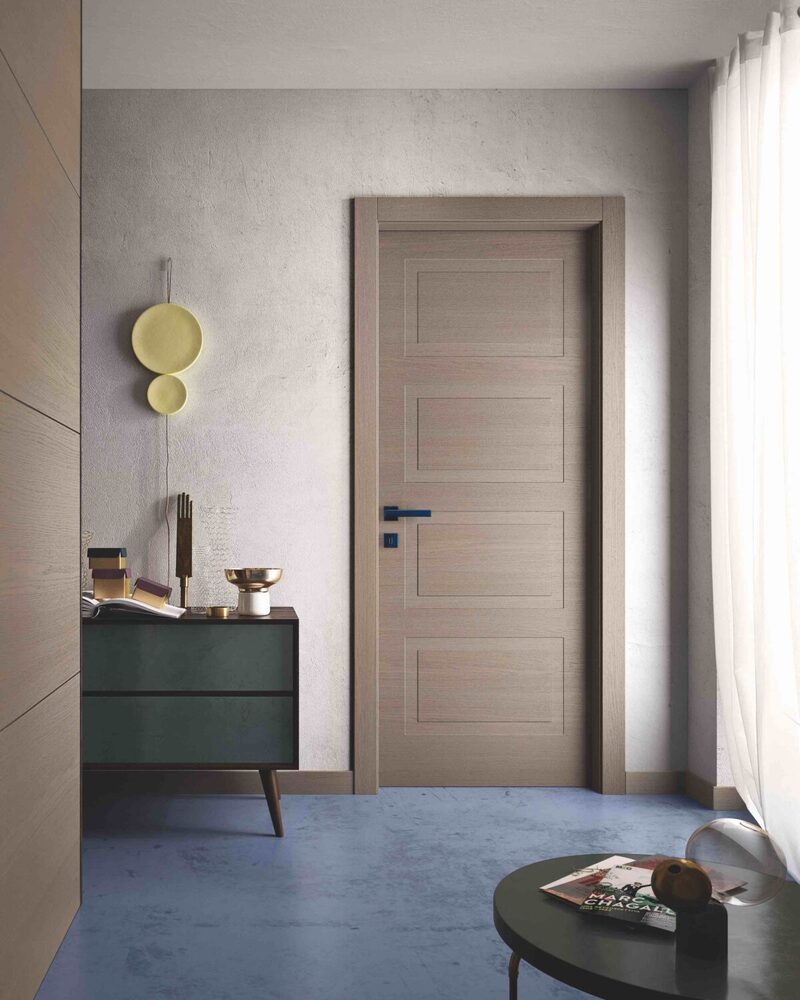 Porta grigio creta collezione Mirawood, abbinata alla maniglia blu